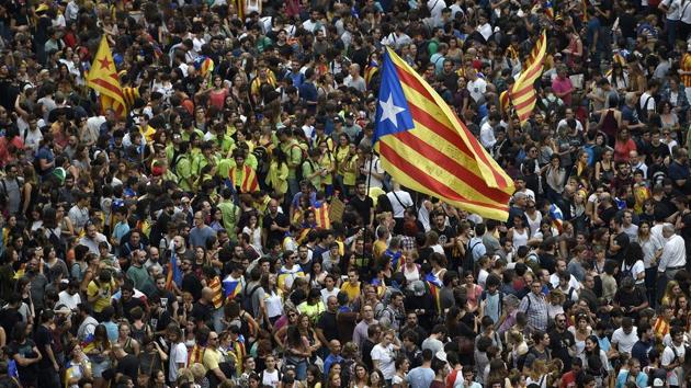 Protesters wave a Catalan pro-independence 'Estelada' flag as they gather at the Placa de la Universitat square in Barcelona during a general strike. (Lluis Gene / AFP) Protesters wave a Catalan pro-independence 'Estelada' flag as they gather at the Placa de la Universitat square in Barcelona during a general strike. (Lluis Gene / AFP)