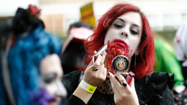 A participant checks theuir costume before taking part in a in a ‘Zombie Walk’ on World Zombie Day in London on October 7, 2017. (AFP)