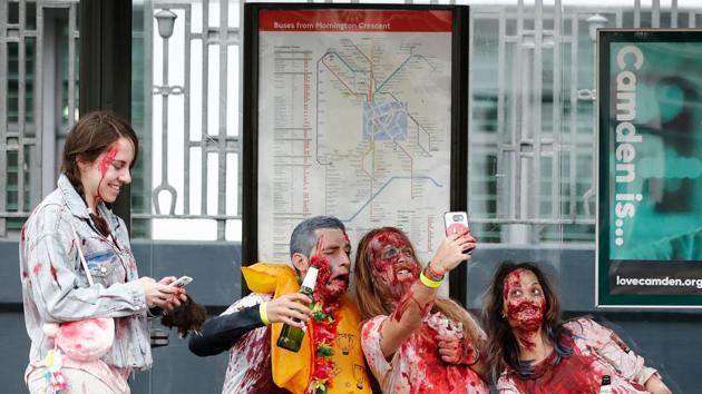People wearing costumes pose for a selfie as they gather at a bus stop before participating in a Zombie Walk in London on October 7, 2017. (AFP)