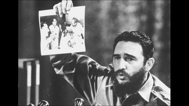 5th July 1968: Cuban Prime Minister Fidel Castro presents a photograph in which General Ovando Candia and other men of the Bolivian Army get drunk to celebrate the murder of Che Guevara. (Keystone / Getty Images)
