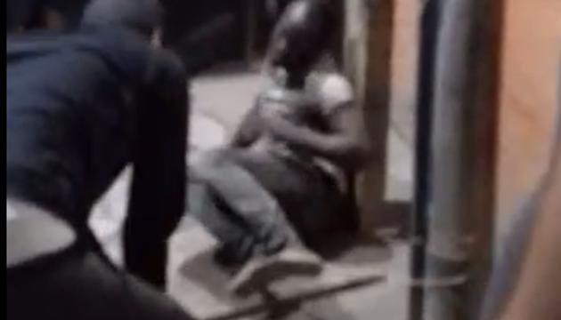 The video shows one of the men from the mob catching the legs of the African national and another hitting him with a stick. (Photo: Image grab from the video) The video shows one of the men from the mob catching the legs of the African national and another hitting him with a stick. (Photo: Image grab from the video)