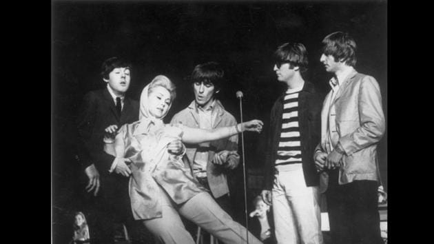 Among the members of the Beatles, Lennon was known for his cool wit. Here from a charity show at the London Palladium in 1964, Hungarian born actress Zsa Zsa Gabor is seen falling into the arms of Paul McCartney as Lennon exhibits his indifference. (Keystone / Getty Images)