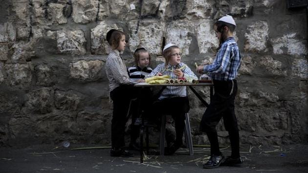 A Jewish youth sells decorations for Sukkahs in the Jewish neighborhood of Mea Shearim, Jerusalem. Thousands of Evangelical Christian pilgrims from across the globe arrive at the holy city for prayers which in biblical times was marked by a pilgrimage to the Ein Gedi temple in Jerusalem. (Oded Balilty / AP)