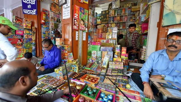 People buy firecrackers near Jama Masjid in old Delhi on Monday. The Supreme Court has banned the sale of firecrackers in Delhi till November 1.(PTI)