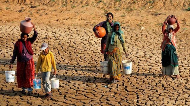 Women return after collecting water from a lake in a drought-hit area in Karnataka.