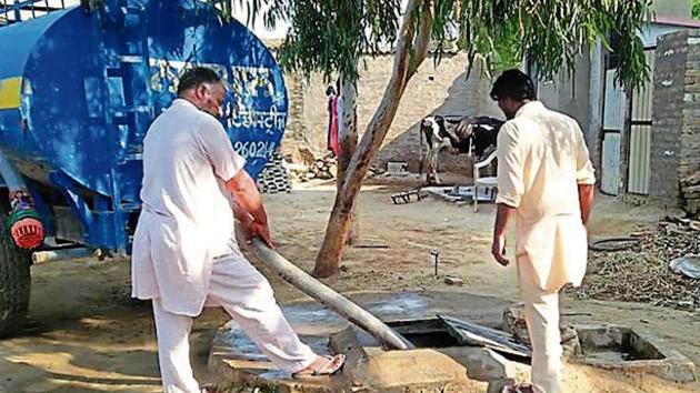 Residents filling up an underground storage tank with water from a tanker at Maan village in Muktsar district on Monday. (HT Photo) Residents filling up an underground storage tank with water from a tanker at Maan village in Muktsar district on Monday. (HT Photo)
