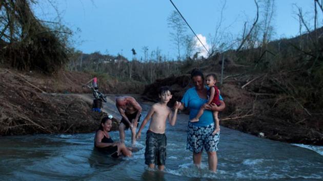 In the Puerto Rican village of San Lorenzo, Hurricane Maria destroyed the two-lane concrete bridge connecting residents with the outside world –making landfall on September 20, 2017. San Lorenzo remains without power or running water ever since. Like many remote villages, San Lorenzo now contends with a silent public health crisis in the wake of the strongest hurricane to hit the island in decades: isolation. (Alvin Baez / REUTERS)