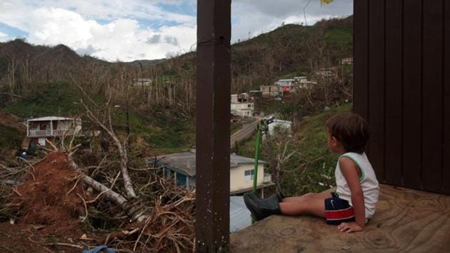 A boy looks out at his neighbourhood in the aftermath of Hurricane Maria in San Lorenzo, Puerto Rico. No one can say when - or if - the bridge will be rebuilt, but it is unlikely to be a high priority on an island with so many needs after the hurricane. (Alvin Baez / REUTERS)