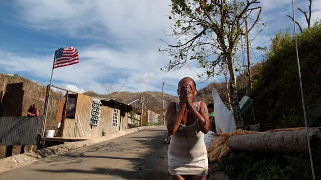 Ruth Santiago, a resident, refreshes herself with water from a pipe, lacking running water in San Lorenzo. Another resident said US officials came and took measurements after the bridge fell but nobody has returned and there is no word about plans for reconstruction. (Alvin Baez / REUTERS)