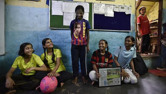 Neelam shows off her Lionel Messi jersey to her fellow team members at the academy in Vikaspuri. She plays in the under-9 category and apart from football, she’s also good at school and drawing. Girls are encouraged to pick up the sport as much as boys in Peter’s ‘My Angels Academy.’ (RAJ K RAJ / HT PHOTO)