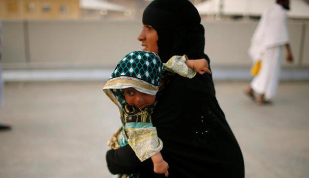 A woman holds a baby as she walks during the annual haj pilgrimage in Mena, Saudi Arabia September 1, 2017.(Reuters File Photo)