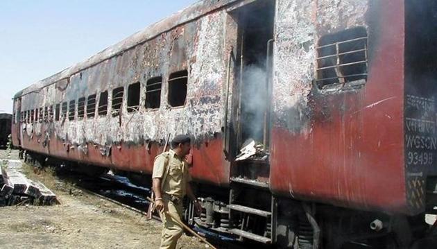 A policeman walks towards the entrance of a carriage of a train in Godhra on February 27, 2002.(Reuters File)