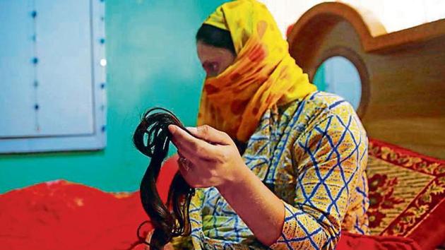 A woman displays her lock of hair that was chopped earlier this month in Srinagar.(Waseem Andrabi/HT File)