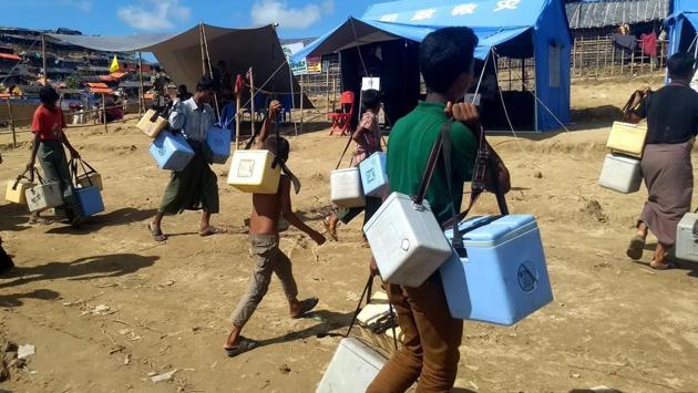 Rohingya volunteers carry ice boxes with cholera vaccines for inoculation at the Thangkhali refugee camp in Ukhia district. (Indranil Mukherjee / AFP ) Rohingya volunteers carry ice boxes with cholera vaccines for inoculation at the Thangkhali refugee camp in Ukhia district. (Indranil Mukherjee / AFP )