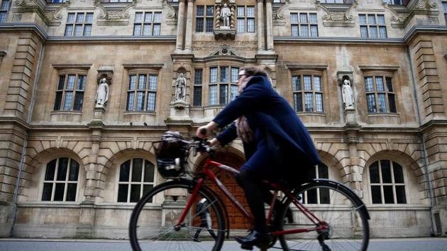 A woman rides a bike next to Oriel College in Oxford, Britain on December 30, 2015. (REUTERS)