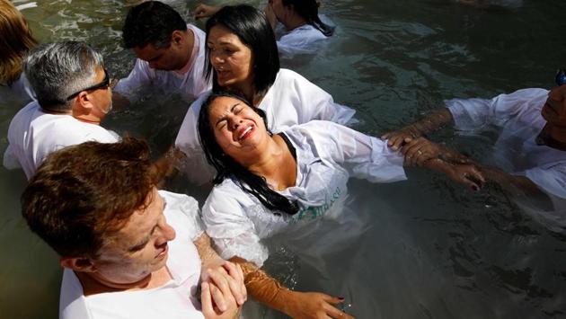 Evagelical Christian pilgrims from Brazil attend a mass baptism ceremony in the waters of the Jordan river in northern Israel during the Jewish holiday. (Menahem Kahana / AFP) Evagelical Christian pilgrims from Brazil attend a mass baptism ceremony in the waters of the Jordan river in northern Israel during the Jewish holiday. (Menahem Kahana / AFP)