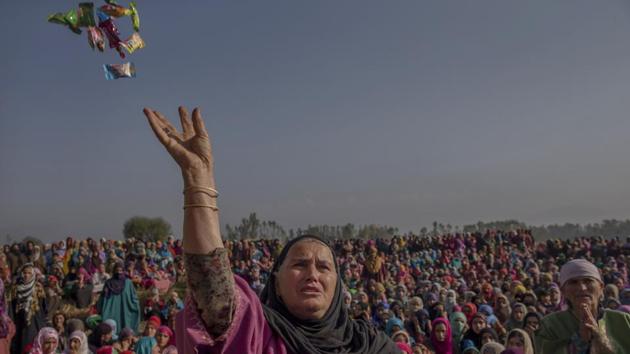 A Kashmiri woman throws candies on the body of Kashmiri rebel Irfan Ahmed (who was killed in combat with Indian government forces) during his funeral in Haf-Shirmal village about 60 kilometers (38 miles) south of Srinagar. (Dar Yasin / AP)