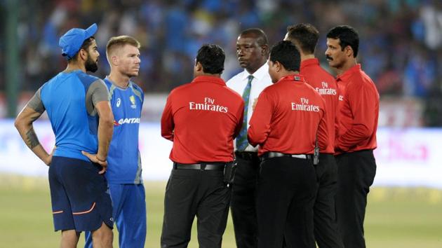 Virat Kohli (L) and David Warner (2L) talk to match referee Richie Richardson (C) and the umpires as play is delayed due to wet outfield on the third and final T20 cricket match between India-Australia at the Rajiv Gandhi International Cricket Stadium in Hyderabad. Catch full cricket score of India vs Australia here(AFP)