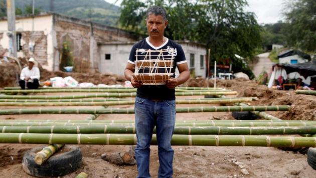 Hector Guzman, 48, peasant and representative of the Municipal President in San Jose Platanar, holds the model of a new house for his father after the earthquake in San Jose Platanar, at the epicentre zone, Mexico. Guzman is building his father a temporary house with bamboo reeds after it was badly damaged. (Edgard Garrido / REUTERS)