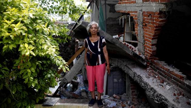 Cenobia Riquelme, 76, a housewife who suffers from Alzheimer's, is seen next to her house in Jojutla de Juarez, Mexico. Riquelme's husband was crushed under the rubble. She now lives in the backyard and hopes to return home once it's rebuilt. Her son Sebastian (not pictured) said: ‘My mother searches for my father to make his lunch. This is all very sad and I am worried.’ (Edgard Garrido / REUTERS)