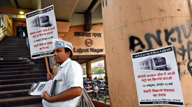An Aam Aadmi Party (AAP) supporter is seen holding flyers that talk about the hike in fares of Delhi metro at Lajpat Nagar Metro Station in New Delhi. (Sanchit Khanna / HT Photo)