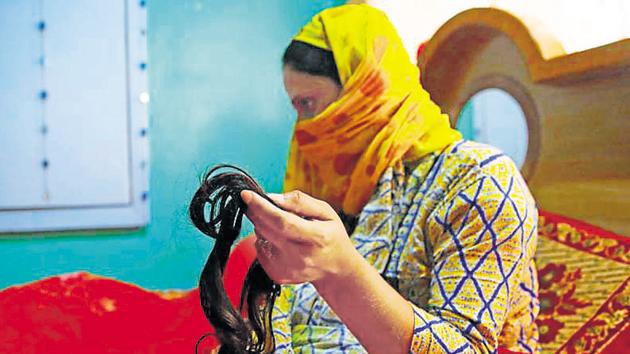 A Kashmiri woman shows her braid, which was cut in central Batamalloo area of Srinagar on October 09. (Waseem Andrabi / HT Photo)