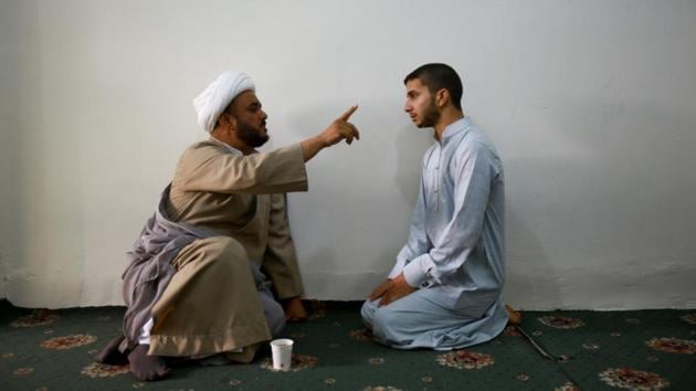 A Shi’ite cleric (L) speaks to a student at Ibn al-Fahd al-Heli school run by the Hawza al-Ilmiyya in Karbala, Iraq. Thousands of students, from teenage boys to university graduates study Islam at its schools in the holy cities of Najaf and Kerbala. (Abdullah Dhiaa Al-deen / REUTERS)