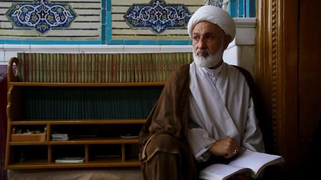 Abdul Hussain Jassim Al Aboudi, 60, a student at al-Gharawiya school run by the Hawza al-Ilmiyya, holds a book, in Najaf, Iraq. (Abdullah Dhiaa Al-deen / REUTERS)