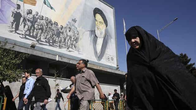 Iranian worshippers walk past a painting of the late revolutionary founder Ayatollah Khomeini and Basij paramilitary force members, at the conclusion of a Friday prayer ceremony in Tehran, Iran, Friday, October 13. (AP Photo) Iranian worshippers walk past a painting of the late revolutionary founder Ayatollah Khomeini and Basij paramilitary force members, at the conclusion of a Friday prayer ceremony in Tehran, Iran, Friday, October 13. (AP Photo)