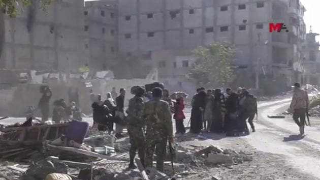 This frame grab from a video provided on October 13 by Turkey-based Kurdish Mezopotamya agency media outlet that is consistent with independent AP reporting, shows US-backed Syrian Democratic Forces (SDF) fighters, stand around Syrian civilians who fled from the areas that still controlled by the Islamic State militants, in Raqqa, Syria. (AP) This frame grab from a video provided on October 13 by Turkey-based Kurdish Mezopotamya agency media outlet that is consistent with independent AP reporting, shows US-backed Syrian Democratic Forces (SDF) fighters, stand around Syrian civilians who fled from the areas that still controlled by the Islamic State militants, in Raqqa, Syria. (AP)