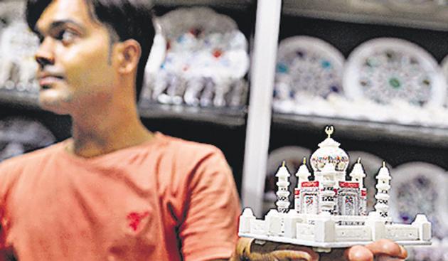 A shopkeeper in Agra shows off a miniature version of the Taj. Miniatures of the monument are popular picks by tourists to the heritage site.(Burhaan Kinu/HT PHOTO)