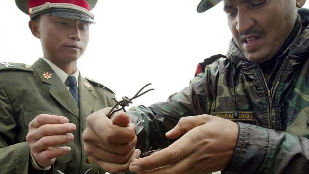 This file photo taken on July 5, 2006 shows a Chinese soldier (L) and Indian soldier placing a barbed wire fence following a meeting of military representatives at the Nathu La border crossing. (AFP Photo) This file photo taken on July 5, 2006 shows a Chinese soldier (L) and Indian soldier placing a barbed wire fence following a meeting of military representatives at the Nathu La border crossing. (AFP Photo)