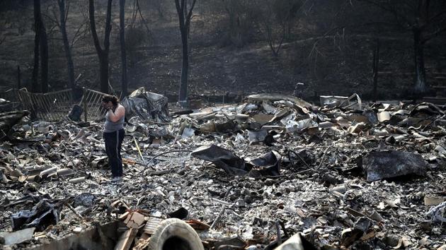 Heather Tiffee wipes her eyes as she looks through the remains of her parents' home after it was destroyed by the Atlas Fire on October 13, 2017 in Napa, California. (AFP Photo)
