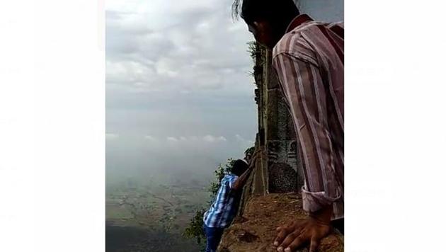 T Arumugam (in the blue shirt), an autorickshaw driver from Musiri town in Tiruchirappalli, moments before he slipped and fell from 2,400 feet while finishing his third circumambulation around the temple on Saturday.(Videograb)