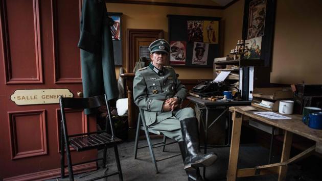 A World War II re-enactor is seen dressed as a German soldier in office during the weekend event. Wearing Nazi uniforms as part of wartime re-enactments is legal in the UK and tends to be a matter for those managing the events to judge. (Oli Scarff / AFP) 
