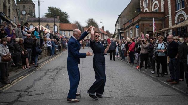 World War II re-enactors danced in the street as they attended the 25th 'Railway in Wartime Event' along the line of the heritage 'North Yorkshire Moors Railway' in Pickering, northern England. (Oli Scarff / AFP) 