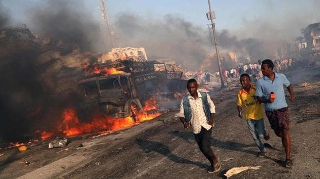 Civilians evacuate the scene of an explosion at KM4 street in the Hodan district of Mogadishu, Somalia. A double truck bombing shattered the night in Mogadishu on Saturday. The dead toll rose to 276 and counting over the weekend with more than 300 injured. (Feisal Omar / Reuters)