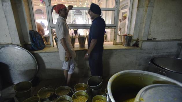 Servers take a break in the kitchen at Bangla Sahib. The fare at langars is always vegetarian, and traditionally comprises simple yet nourishing food-- usually dal, roti, vegetables, salad and papad. (Raj K Raj / HT Photo)