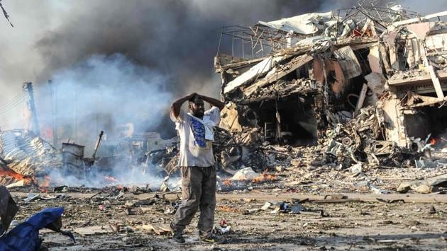 A Somali man reacts next to a dead body on the site of the twin explosion. The blast occurred at a junction in Hodan, a bustling commercial district in the capital Mogadishu which houses many shops, hotels and businesses. Hundreds of people had been in the area at that time, resulting in the worst terror attack in the country till date. (Mohamed Abdiwahab / AFP)