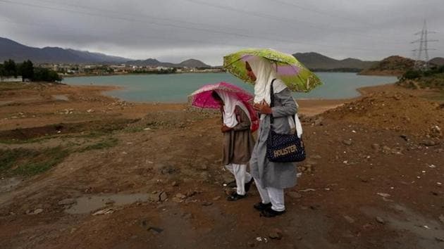 Afghan school girls hold umbrellas to shelter from rain on outskirt of Kabul in Afghanistan.(Reuters Photo) Afghan school girls hold umbrellas to shelter from rain on outskirt of Kabul in Afghanistan.(Reuters Photo)