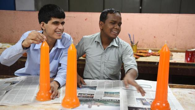 Arun Kumar Lohra (R), a student at a vocational training centre run by the Blind Relief Association in New Delhi makes candles for Diwali, which will go up on sale at the popular Blind School Diwali Mela. (Sanchit Khanna / HT Photo) 