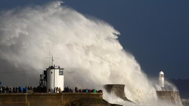 Huge waves strike the harbor wall and lighthouse at Porthcawl, South Wales, on October 16, 2017 as Storm Ophelia, downgraded from a hurricane arrives in the UK and Ireland. Ophelia ramming Ireland on Monday left three people dead, 330,000 homes and businesses without power, the shutting of schools and the grounding of planes in the country. (Geoff Caddick / AFP)