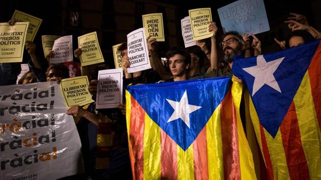 People hold Esteladas (Pro-independence Catalan flag) and papers reading in Catalan "Freedom political prisoners" in front of the Generalitat Palace on October 17, 2017 in Barcelona. (AFP) People hold Esteladas (Pro-independence Catalan flag) and papers reading in Catalan "Freedom political prisoners" in front of the Generalitat Palace on October 17, 2017 in Barcelona. (AFP)
