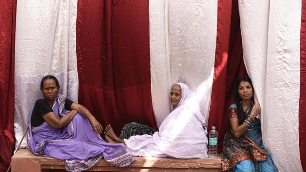 A widow (centre) watches Vinita’s marriage ceremony from the sidelines. In a major departure from tradition, remarriage was celebrated in the city where most widows take refuge. (Burhaan Kinu / HT Photo)