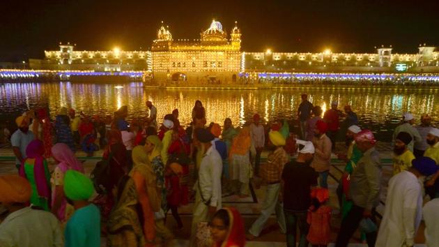 Devotees pray inside the Golden Temple, decorated with lights on the eve of Diwali festival, in Amritsar on Wednesday. (Sameer Sehgal/HT)