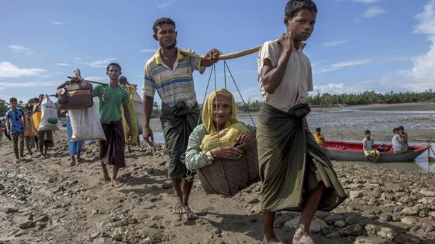 Rohingya Muslims, who crossed over from Myanmar into Bangladesh, carry an elderly woman in a basket and walk towards a refugee camp in Shah Porir Dwip, Bangladesh, September 14.