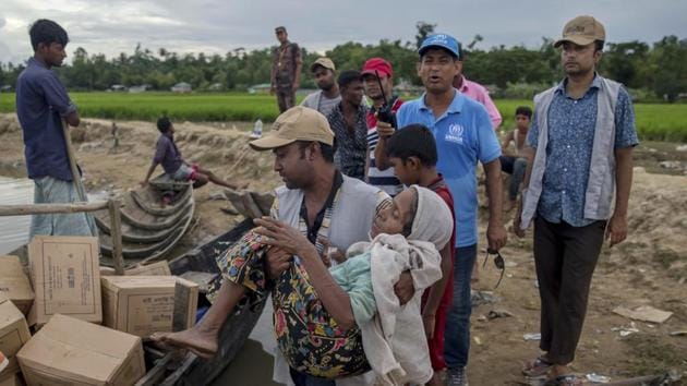 A Bangladeshi man carries a Rohingya Muslim woman Rajamma, who crossed over from Myanmar into Bangladesh, towards a boat filled with food aid for stranded refugees in Palong Khali, Bangladesh, Wednesday, Oct. 18, 2017. (AP) A Bangladeshi man carries a Rohingya Muslim woman Rajamma, who crossed over from Myanmar into Bangladesh, towards a boat filled with food aid for stranded refugees in Palong Khali, Bangladesh, Wednesday, Oct. 18, 2017. (AP)