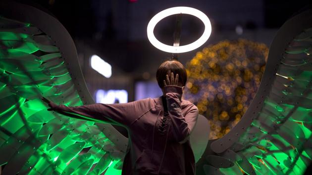 A girl poses with angel wings and a halo at a light festival in Beijing, China. The installation in a shopping mall is a creative attempt at drawing in visitors by creating a friendly atmosphere. (Ng Han Guan / AP)