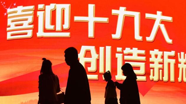People pass a billboard reading ‘Welcome the 19th Congress. Create New Achievements’ ahead of the opening of the National Congress. Coverage in state media and across the city is in overdrive with large red banners plastered around Beijing welcoming the congress, while censors have stepped up already tight monitoring of the internet. (Greg Baker / AFP)