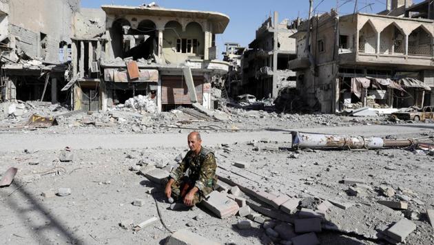 A fighter of Syrian Democratic Forces rests on rubble after Raqqa was liberated from the Islamic State militants, in Raqqa, on Tuesday. (Reuters)